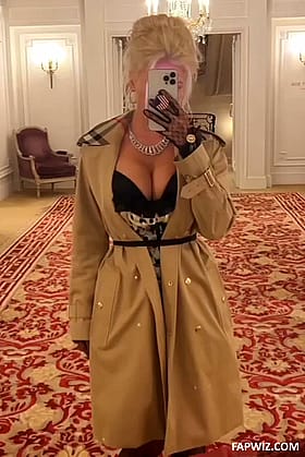 Blond Babe in a Coat Taking a Selfie